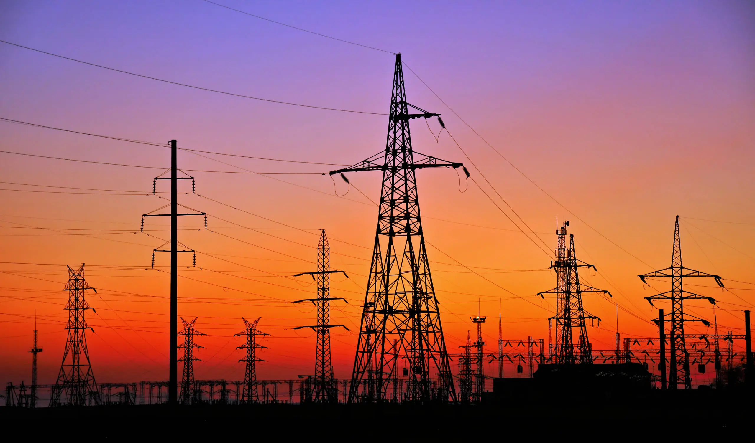 Photo of electric towers against sunset