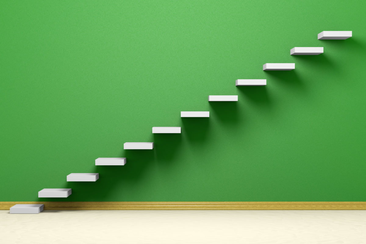 Ascending stairs of rising staircase in empty green room